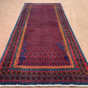 Front view of a handmade Afghan wool rug in blue with Baluchi tribal patterns