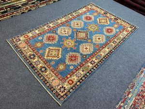 Vintage red Afghan handmade wool rug, close-up of intricate design.